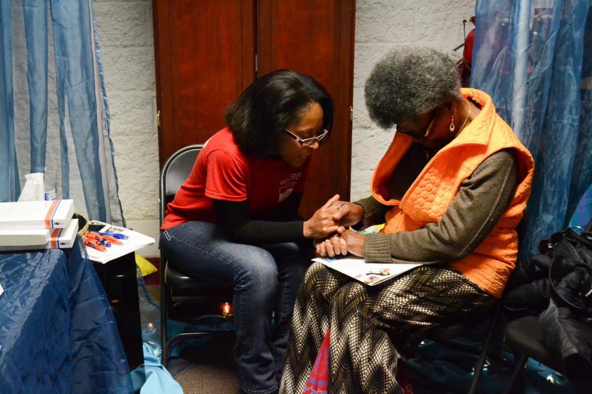 WGTS Prayer team member Gladys Guerrero prays with a listener