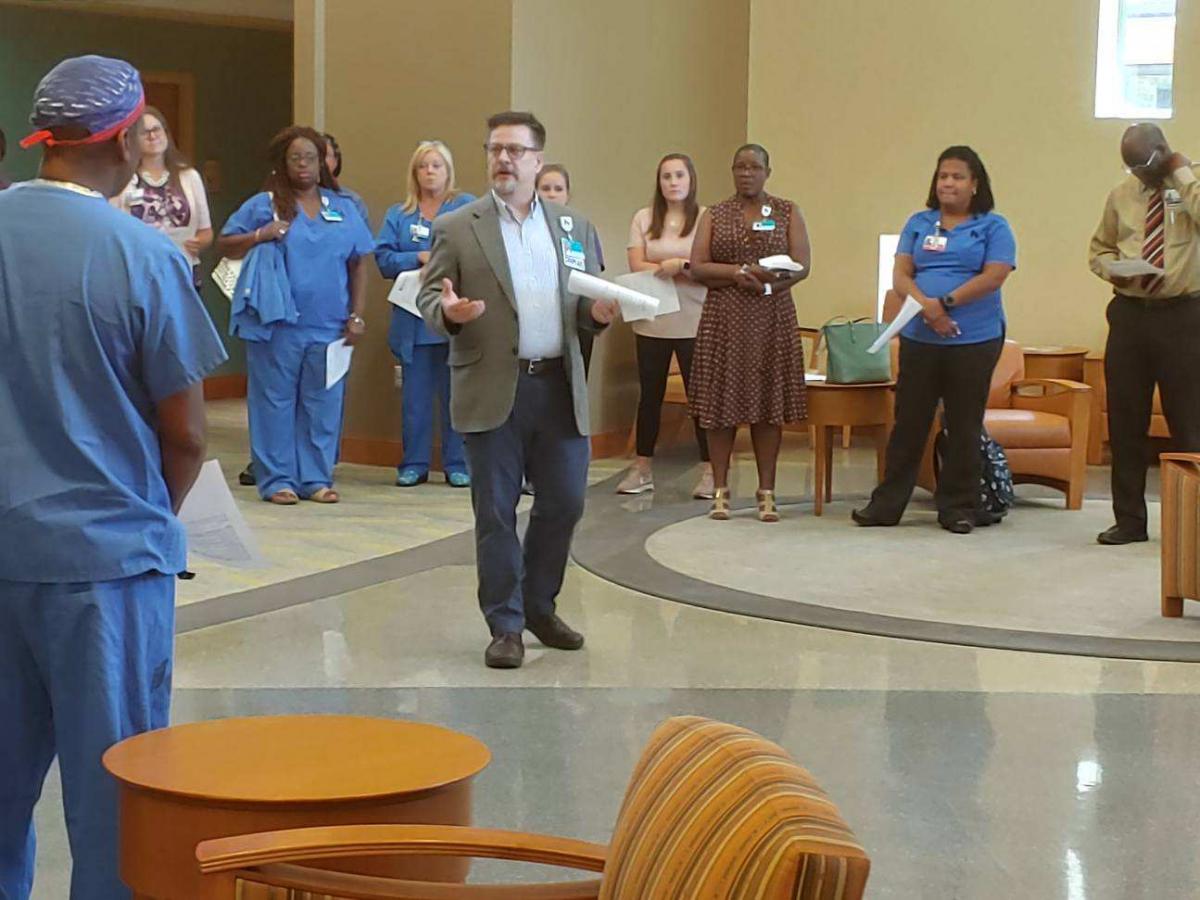 Mark Feldbush talks to employees during a prayer vigil.