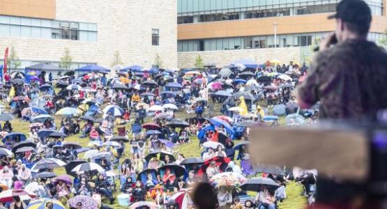 CAIN sings along to a crowd of umbrellas.