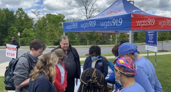 WGTS CEO Kevin Krueger prays with listeners at the prayer stop in front of Adventist HealthCare’s White Oak Medical Center in Silver Spring, Md.