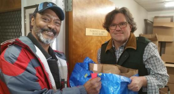 A holiday food basket recipient thanks an ACSGW volunteer for the special Thanksgiving meal he received on Nov. 25, 2019. Photo by Alicia Tucker/ACSGW