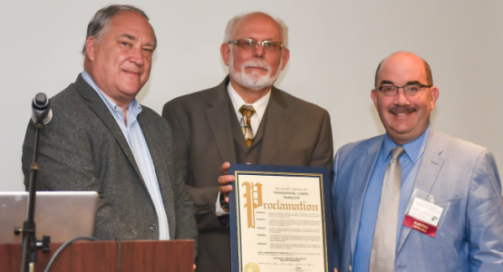 Montgomery County Council members Mark Elrich (left) and George Leventhal (right) present a proclamation of congratulations for ACSGW’s 35 years of service to Ken Flemmer, executive director. 
