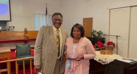 Carlos Mcconico presents plaque to yoland wise Wesley at mount Zion miracle station