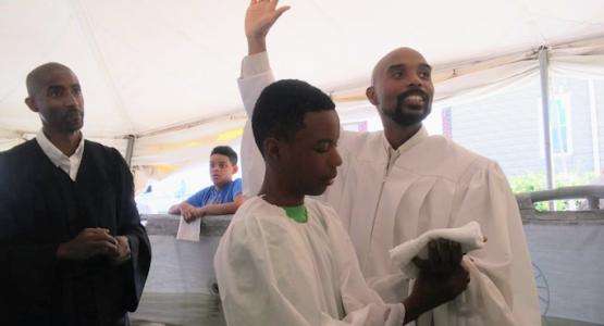 Donald McKinnie, Jr., pastor of the Hillside church, baptizes his son, Nathan, during the church’s tent revival. Evangelistic Meetings Bring Hope to Harrisburg, Hillside church, Conklin Gentry, Donald McKinnie, Jr.,