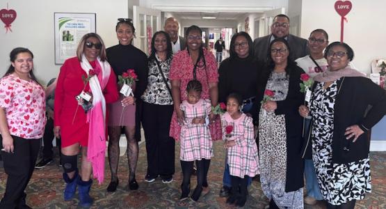 Penuel church members stand in the lobby of the Culpeper Health and Rehabilitation Center with a staff member before distributing roses to its 174 residents. Penuel Church Spreads Love to Local Rehab Center, Allegheny East Conference, Penuel church, Culpeper Health and Rehabilitation Center, James Thomas