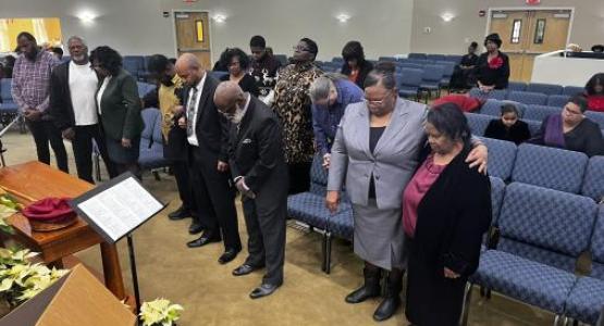 Trevor Donaldson (in white shirt and tie), lay pastor of the St. Leonard Emmanuel church, prays alongside leaders during Ministries’ Appreciation Day.