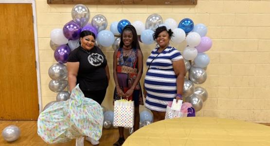 Expectant mothers display gifts they received from the Community Baby Shower. 