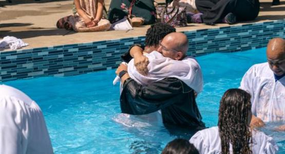 Carlos Quiroga, pastor of Nueva Esperanza church in Delaware, Ohio, embraces a newly baptized member.