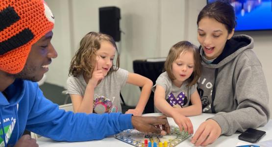 Charleston Boulevard members Christian Baker, Destiny Goad, Serenity Goad and Ellana Garcia play a board game together at the church’s community center. 