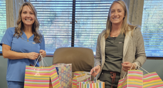 Grasonville member Sue Tyler (right) presents “Blessing Bags” to a staff member at the Bay Hematology and Oncology Center.