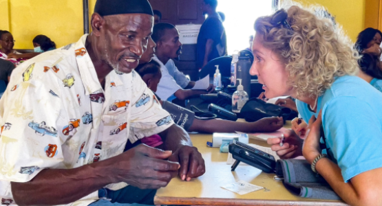 New Hope member Monika Korff (right) provides a medical screening to a Grenadian.