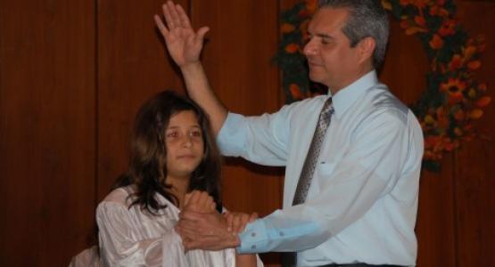 Pastor Orlando Rosales prepares to baptize a Baltimore Spanish member