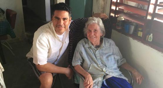 Pastor César González visits with Cenaida Fort Defaus, a Cuban member who opens her home as a meeting place for her church.