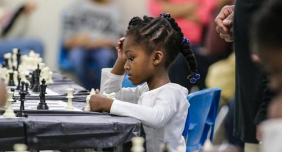 Nia Burton, BJA kindergartener, concentrates before she makes her next move at the chess tournament.