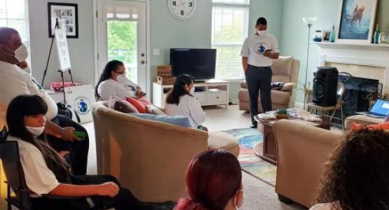 Elder David Santiago opens his home for members of the Lorain Hispanic church plant, as Pastor Anthony Infantes (pictured standing) shares the Word of God.