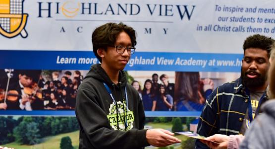 Sophomore Matt Dela Paz and academy Chaplain Elijah Ramjattan share information with attendees at a recent GYC meeting. Building a Spiritual Oasis in Western Maryland, Highland View Academy, Chesapeake Conference, Generation of Youth for Christ conference, GYC