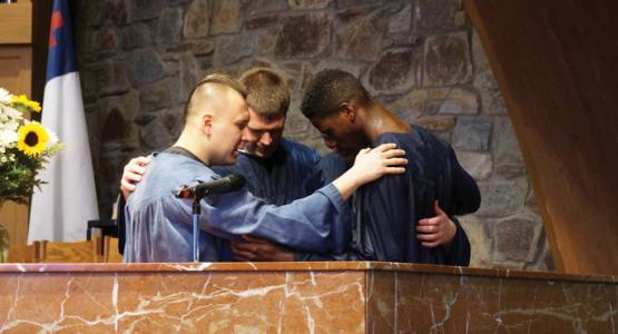 Justin Montero and Spencerville youth pastor Stephen Finney pray with Jacob Harris at Harris’ baptism. Photo credit: Juliana Baioni