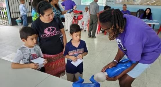 Washington Adventist University student Juan Carlos (right) teaches CPR to kids in El Salvador.