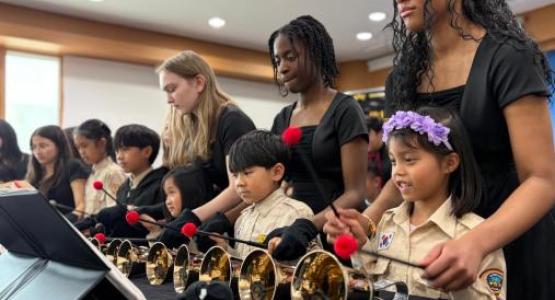 La Sonnette members Meagan Nims, Harmony John and Jairine Almeida teach young students how to play the bells in South Korea.