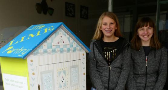 Kate Sharbaugh and Emma Schartner stand with one of their pantries.