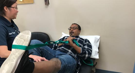 Lynda Hiponia, a physical therapist with Adventist HealthCare Rehabilitation, helps fire survivor Memar Ayalew regain strength and mobility in his leg.