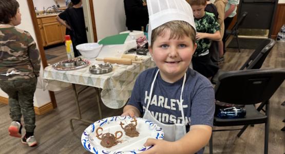 Community visitor Cooper Brown displays a recipe he made. Juniors Become Chefs at Buckhannon, Mountain View Conference, Eight Principles of Health, Melonie Gerath, Junior Chef’s Christmas Cookie Bake-Off