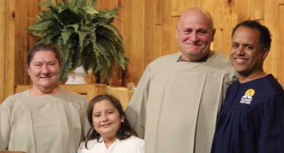 Jaime Rodriguez (right), pastor of the Summersville church, introduces baptismal candidates Amy Perdue (left), Brayleigh Lafferty and Jackie Perdue to the congregation. Photo by Jenny Rodriguez