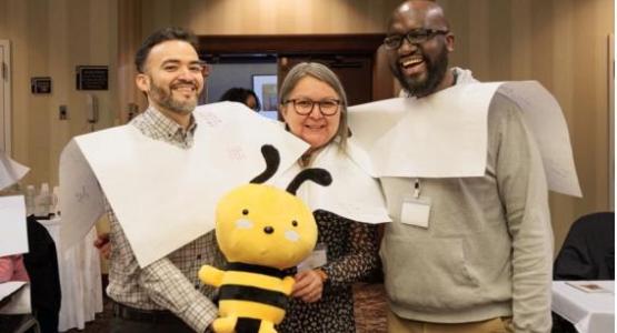 New Jersey Conference teachers Jason Chavez, Lilia Torres and John Hakizimana hold the conference’s mascot, Buzz the Bee, during a team exercise.
