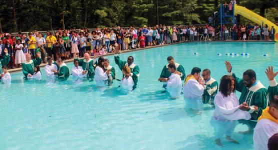 Sixty-four people, Hispanic and non-Hispanic, celebrate baptism during the Hispanic Camp Meeting