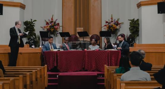 Jason Miller (standing) discusses a Sabbath School lesson with First Church of Teaneck panelists Elvys Mutis, Jonathan Mays and Asabie Hoyte, alongside two other panelists Sabrina and Victor Mills. Allegheny East Conference, First Church of Teaneck, "Sabbath Impact Day", Robert T. Smith