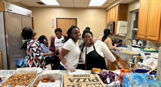 Columbus Ghanaian church members Patience Adjei and Serwaa Afrifa serve food to the youth and young adults.