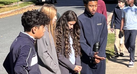While prayer walking in the school’s neighborhood, eighth grade students pause to ask God’s blessing on a home.