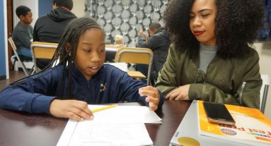 Amy Thomas, a student at Temple University, tutors third-grader Jodi Glenn as part of the REACH Success after-school program.