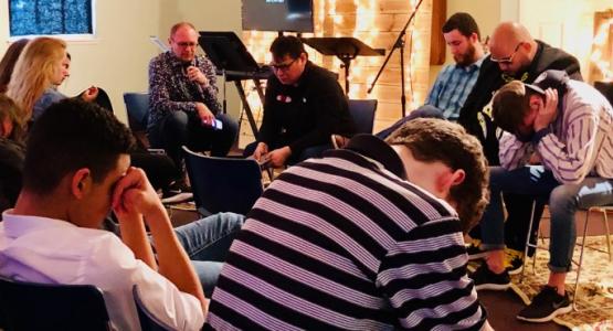 Edward Marton, Ohio Conference’s Youth Ministries director, leads prayer with high school students and youth pastors during the “ReCharge” event at the Worthington church.