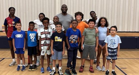 Patrice Sosa (center), middle school girls’ soccer coach, pauses for a photo with his energetic campers. Academy Launches New Summer Camp Program, Spencerville Adventist Academy, Outdoor Discovery Camp, Joshua Adventist Multigrade School, Lynette Louie-Nelson