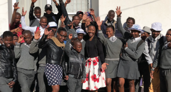 Sidney Harris (white skirt), a member of the Ephesus church in Richmond, Va., waves hello with a group of students who decided to get baptized as a result of Harris’ ministry in Lesotho.