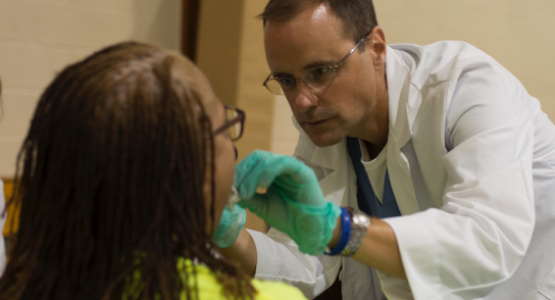 Kettering College (Ohio) physician assistant and Professor Tim Scanlon performs an oral exam on an attendee during the Ephesus church-sponsored Community Health Emphasis Weekend. Kettering College (Ohio) physician assistant and Professor Tim Scanlon performs an oral exam on an attendee during the Ephesus church-sponsored Community Health Emphasis Weekend.