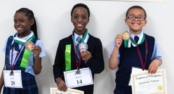 Science Fair primary winners llide Iheme, third place (BJA); Daniel Lightbody, second place (W. F. Mays); and Lawrence Talbert, first place (Dupont) display their medals.