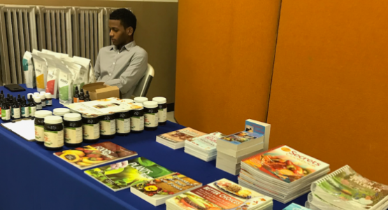 Wellness instructor Ezra St. Juste staffs the natural remedy literature display table at the Community Health Expo.