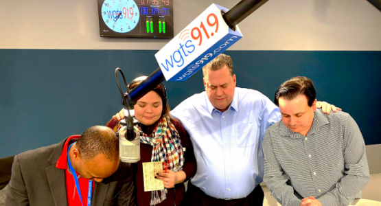 Morning show hosts Jerry Woods and Blanca Vega, General Manager Kevin Krueger and morning show producer Spencer White pray during a break.
