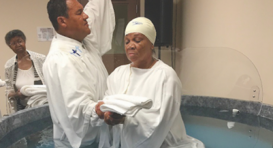 Stephen D. Lewis, pastor of the Dayton church, baptizes Brenda Rutledge.