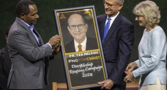 Prime Minister of Papua New Guinea gifts Ted Wilson a painting as a thank you for the evangelistic series held in his country. The 62nd General Conference Session of the Seventh-day Adventist Church, America’s Center Convention Complex, St. Louis, Missouri, Seth Shaffer/ AME (CC BY 4.0) Prime Minister of Papua New Guinea gifts Ted Wilson a painting as a thank you for the evangelistic series held in his country. The 62nd General Conference Session of the Seventh-day Adventist Church, America’s Center Convention Complex, St. Louis, Missouri, Seth Shaffer/ AME (CC BY 4.0)
