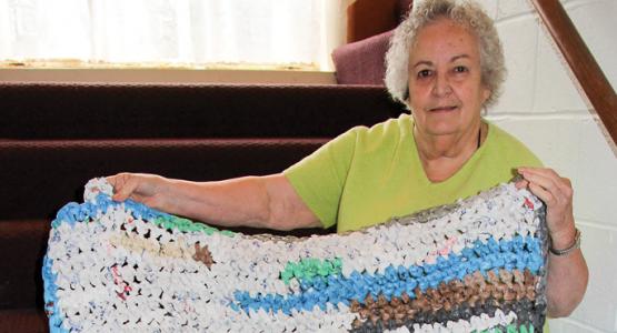 Shirley Crouser shows a soft mat made from colorful plastic grocery bags which will bring warmth to a homeless person.