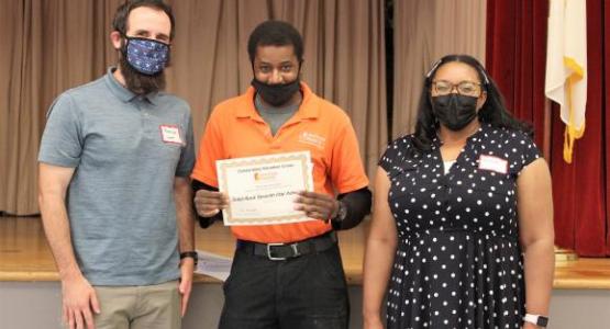 Donald Richardson, volunteer coordinator at the center, presented the award (pictured with Solid Rock members Patrick Long and Romana Lavalas)