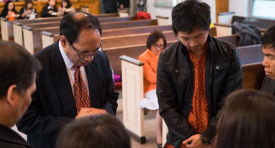 Pastor Steven Rantung prays with members grappling with immigration issues