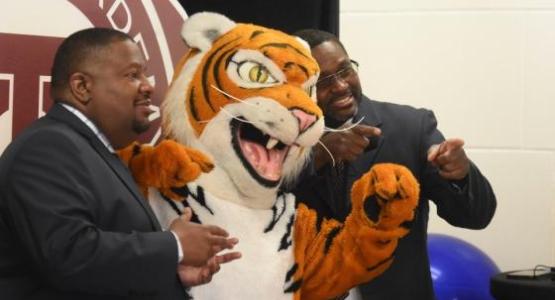 Tiger, Takoma Academy’s mascot, is flanked by Vice Principal Keith Beckett and alumnus Melvyn Hayden III (’89).