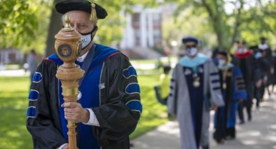 Grant Leitma leads the faculty and staff at the beginning of the WAU Commencement Ceremony.