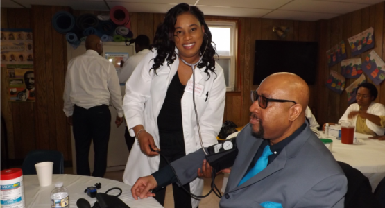 Willow Grove church member Rosemarie Webster takes blood pressure from frequent visitor Dornell LaVant during the Community Outreach Day.