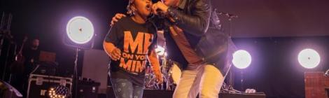  Matthew West singing with a young fan on stage. 