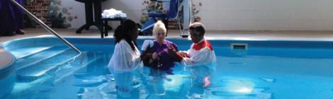 Rosalind Beswick and Carl Rogers help Susan Riddle (center) prepare for her baptism.